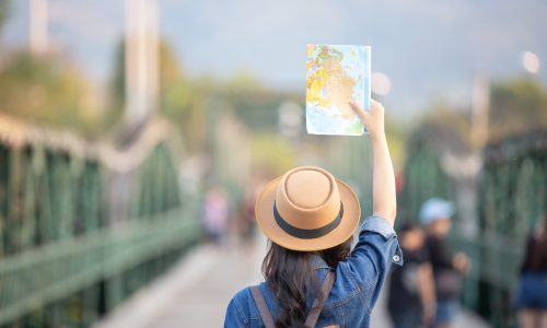 Female tourists on hand have a happy travel map.